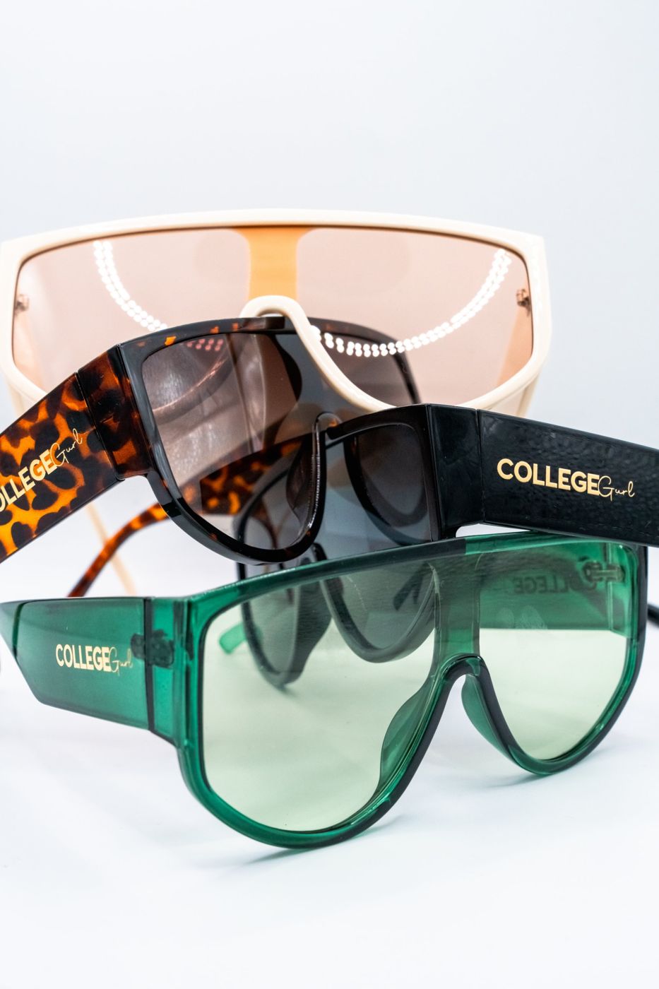 Creme, tortoise, black, and green College Gurl Sunnies stacked together